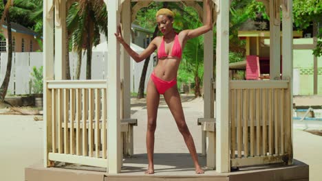Una-Chica-Negra-Disfruta-De-La-Belleza-De-Una-Playa-Caribeña,-Vestida-Con-Un-Bikini-Rojo-Vibrante.
