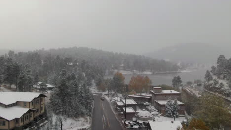 Downtown-Evergreen-Lake-Colorado-historic-downtown-aerial-drone-blizzard-fall-autumn-winter-first-snowfall-colorful-aspen-trees-dam-lake-house-Rocky-Mountain-front-range-Denver-town-forward-motion