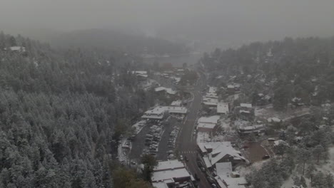 Downtown-Evergreen-foggy-Colorado-historic-downtown-aerial-drone-blizzard-fall-autumn-winter-first-snowfall-Rocky-Mountains-front-range-Denver-left-motion-reveal
