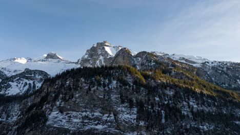 Zeitraffer-Von-Wolken,-Die-über-Schneebedeckten-Alpengipfeln-Mit-Bäumen-Vorbeiziehen