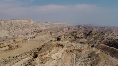 panorama-view-of-wind-erosion-formation-landform-coastal-desert-climate-dry-mud-rocky-mountain-in-background-high-altitude-in-Hormuz-island-dragon-beach-in-Iran-natural-landscape-Qatar-border-marine