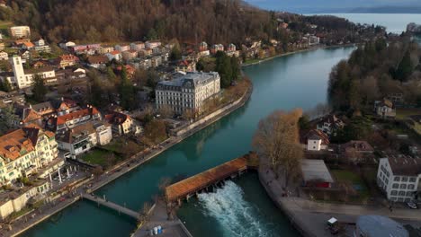 Flowing-river-Aare-sluice-in-Thun-old-town,-lake-Thun-and-Alps-beyond