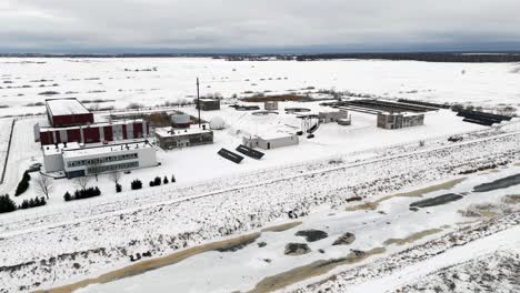 Snow-covered-water-treatment-plant-location,-winter-in-Silute,-Lithuania,-drone-flight