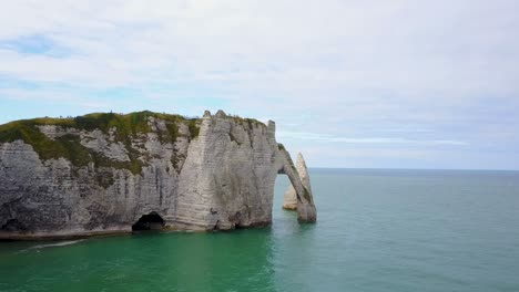 Flying-toward-the-rocky-arch-of-Etretat-on-the-coastline-of-France-in-Normandy
