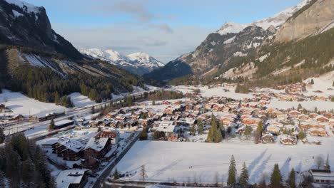 Picturesque-town-in-snowy-sunlit-mountain-valley-in-Swiss-Alps