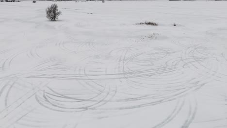 Snow-drifts-from-above,-drone-perspective-on-wintry-tracks
