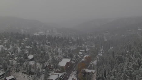 Downtown-Evergreen-Lake-Colorado-historic-downtown-aerial-drone-blizzard-fall-autumn-winter-first-snowfall-colorful-aspen-trees-dam-lake-house-Rocky-Mountain-front-range-Denver-forward-pan-down
