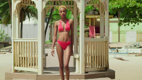 An-Einem-Reiseziel-In-Der-Karibik-Ziert-Ein-Mädchen-Afrikanischer-Abstammung-Den-Strand-In-Einem-Leuchtend-Roten-Bikini