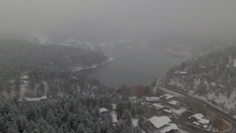 Downtown-Evergreen-Lake-Colorado-historic-downtown-aerial-drone-blizzard-fall-autumn-winter-first-snowfall-colorful-aspen-trees-dam-lake-house-Rocky-Mountain-front-range-Denver-forward-down-motion