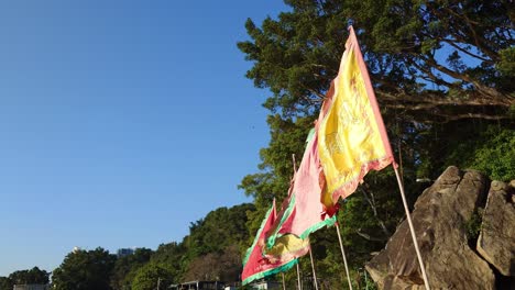Toma-Estática-De-Banderas-Multicolores-De-Un-Templo-Chino-Ondeando-En-Un-Día-Ventoso-En-Lei-Yu-Mun,-Hong-Kong.