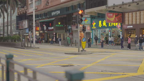 People-walk-across-the-street-in-Hong-Kong,-China