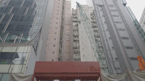 Ein-Kran-Transportiert-Eisenstangen-Während-Des-Baus-Eines-Mehrfamilienhauses-In-Hongkong,-China
