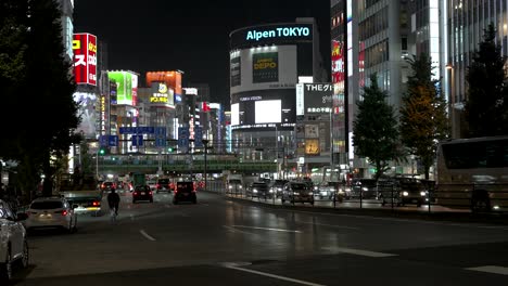 Evening-Traffic-Driving-Along-Tokyo-Metropolitan-Road-Route-4-In-Shinjuku-With-Bright-Neon-Illuminated-Buildings-In-Background