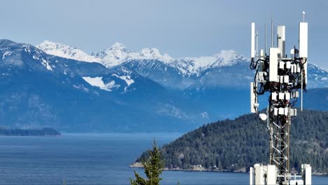 Antena-De-Torre-De-Telecomunicaciones-Con-Sonido-Howe-Y-Montañas-Nevadas-Al-Fondo-En-BC,-Canadá