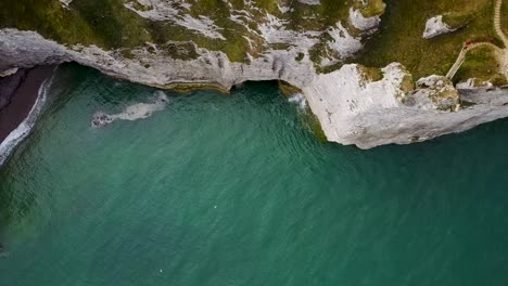 Flying-up-from-the-water-level-above-the-rocky-arch-of-Etretat-in-France