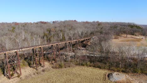 Aerial-Shot-Pushing-Across-a-Field-Towards-the-Pope-Lick-Railroad-Trestle-in-Louisville-Kentucky-on-a-Sunny-Afternoon