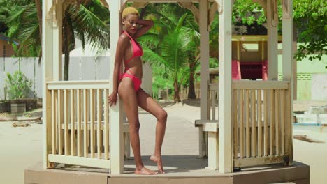 In-Einer-Malerischen-Karibischen-Umgebung-Zieht-Eine-Frau-Afrikanischer-Abstammung-Einen-Roten-Bikini-Am-Weißen-Sandstrand-An