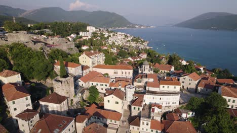Drone-flying-backward-over-Nikola-djurkovic-square-in-Herceg-Novi,-Coastal-village-in-Montenegro