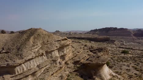 Landing-drone-shot-landform-erosion-on-rocky-mountain-formation-polished-by-wind-in-coastal-beach-tropical-climate-in-Qatar-Iran-sand-mud-pillar-stone-near-the-sea-in-gulf-Hormuz-Island-scenic-view