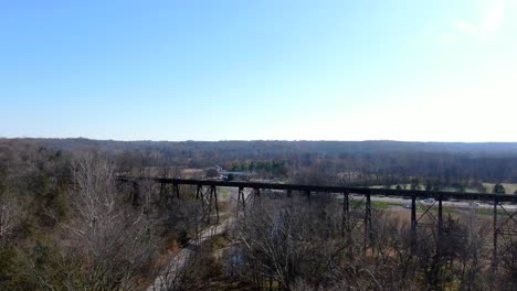Aerial-Shot-Pushing-Over-a-Forest-Towards-the-Pope-Lick-Trestle-in-Louisville-Kentucky-on-a-Sunny-Afternoon