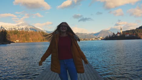 4K-video-of-a-beautiful-happy-young-caucasian-female-walking-down-the-pier-at-a-very-famous-touristic-destination-Bled,-Slovenia