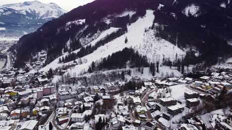 Ski-slope-and-townscape-of-Austrian-town-of-Zell-Am-See,-aerial-establishing