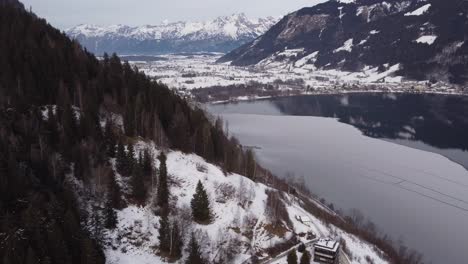 Austrian-Alpine-frozen-winter-lake-in-Zell-Am-See,-aerial-view,-pull-back