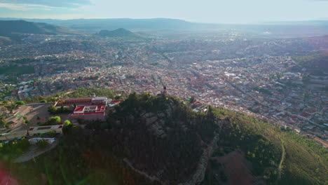 Drone-footage-orbits-around-Cerro-de-la-Bufa-in-Zacatecas,-focusing-on-its-iconic-lighthouse-with-a-smooth-lateral-movement,-showcasing-the-stunning-cityscape