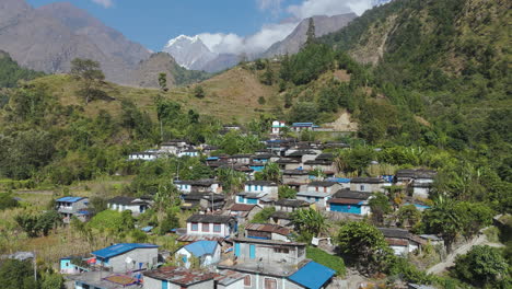 Drone-shot-of-Nepali-Village-at-Annapurna-region,-Mountain-in-background-with-Inhabitation-of-diverse-ethnic-citizens-in-Pokhara-Nepal,-Landscape-in-sunny-weather-4K