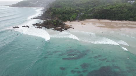 Surfers-At-The-Pass-Beach-In-Byron-Bay,-Australia---Aerial-Drone-Shot