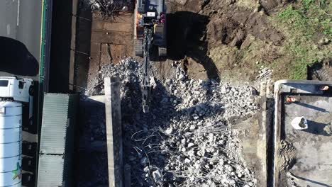 Aerial-drone-shot-of-piles-of-concrete-after-destruction-of-highway-bridge