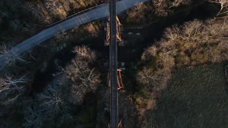 Aerial-Top-Down-Shot-of-the-Pope-Lick-Railroad-Trestle-and-the-Surrounding-Woods-and-Stream-During-Sunset-in-Louisville-Kentucky