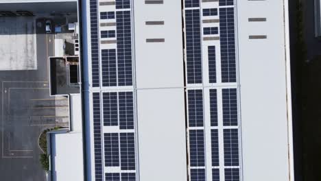 Aerial-view-of-solar-panel-system-on-facility-roof,-top-down-close-up,-dolly-out