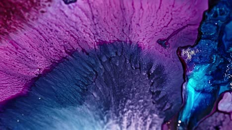 Close-up-of-vibrant-purple-and-blue-ink-diffusing-in-water,-creating-an-abstract-pattern