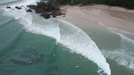 Aerial-View-Over-Surfers-At-The-Pass-Beach-In-Byron-Bay,-Australia---Drone-Shot