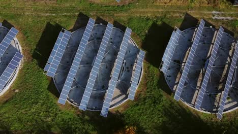 Solar-panels-arranged-in-circular-and-rectangular-structures-in-rural-Greece,-bird's-eye-aerial