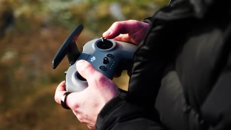 Hold-drone-remote-control-and-operate-flight-with-joysticks-using-fingers