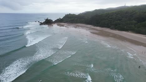 Ocean-Waves-Splashing-Sandy-Shore-Of-The-Pass-Beach-In-Byron-Bay,-Australia---Aerial-Drone-Shot