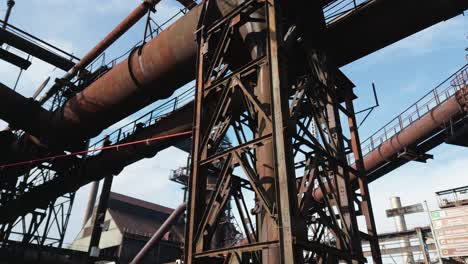 Große,-Alte-Und-Verrostete-Industrielle-Metallkonstruktionen-Unter-Klarem-Himmel