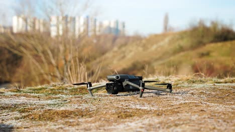 Person-with-black-leather-gloves-put-drone-on-ground,-prepare-for-take-off