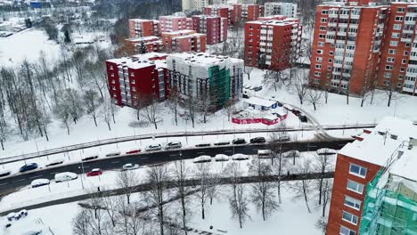Aerial-view-of-5-story-high-building-covered-for-renovation,-during-snowy-winter