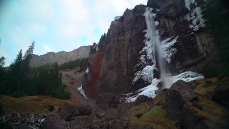 Telluride-Colorado-sunset-stream-Bridal-Veil-Falls-frozen-ice-Waterfall-fall-autumn-cool-shaded-Rocky-Mountains-Silverton-Ouray-Millon-Dollar-Highway-afternoon-historic-town-landscape-slow-pan-up
