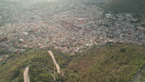 Aerial-drone-footage-captures-the-stunning-cityscape-of-Zacatecas-from-Cerro-de-la-Bufa,-descending-to-reveal-the-historic-center's-narrow-streets-and-alleys