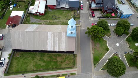 Aerial-Drone-Rotate-Above-Patrimonial-Chilean-Church-in-Dalcahue-Chiloé-Island-around-Streets-and-Local-Neighborhood