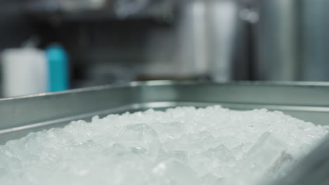 Close-up-view-of-a-chef-collecting-ice-from-a-aluminum-tray-in-a-kitchen-of-a-French-chef-restaurant