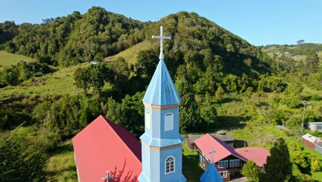 Aerial-Panoramic-Landscape-of-Chiloé-Patrimonial-Church,-Tenaun-Hills,-Skyline-and-Blue-Architecture,-Religious-Landmark