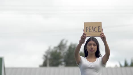 Sosteniendo-Un-Signo-De-Paz-Joven-Latinoamericana,-Guerra-De-Protesta-Latina
