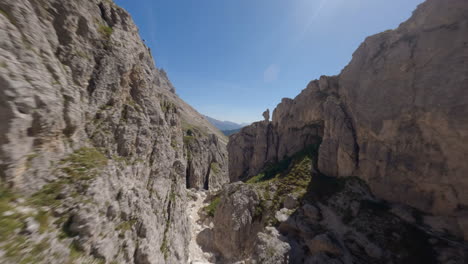 Drone-flying-between-mountain-rocks-with-plateau-in-background,-Dolomites,-Italian-mountains