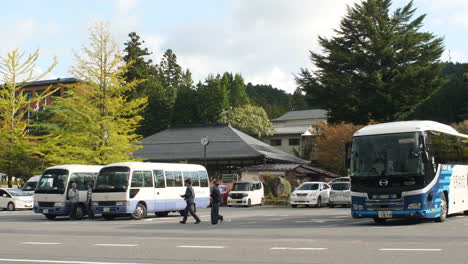 Touristen,-Die-Am-Kongobuji-Parkplatz-Vorbeigehen,-Mit-Geparkten-Reisebussen,-Die-Koyasan-Besuchen