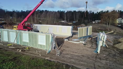 Modular-home-assembly-on-construction-site-with-crane